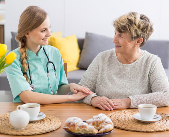 A nurse and patient have tea together.